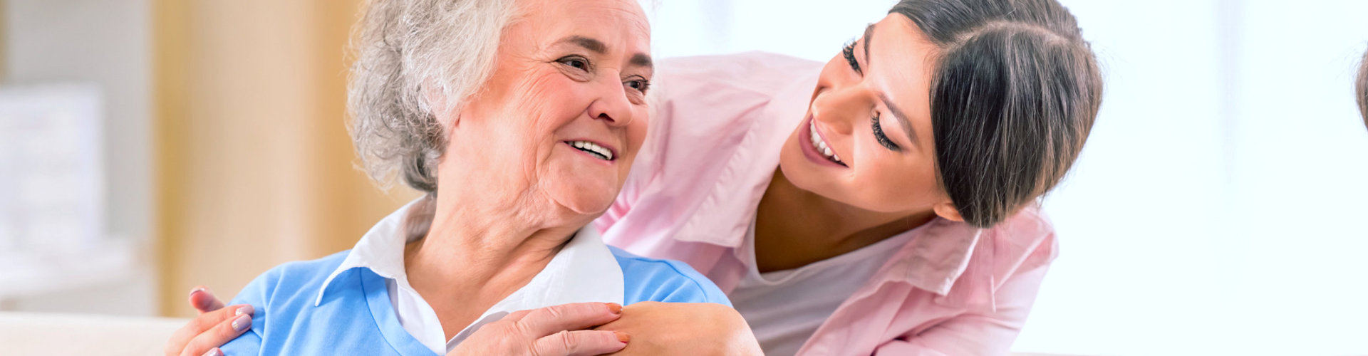senior woman smiling with her caregiver